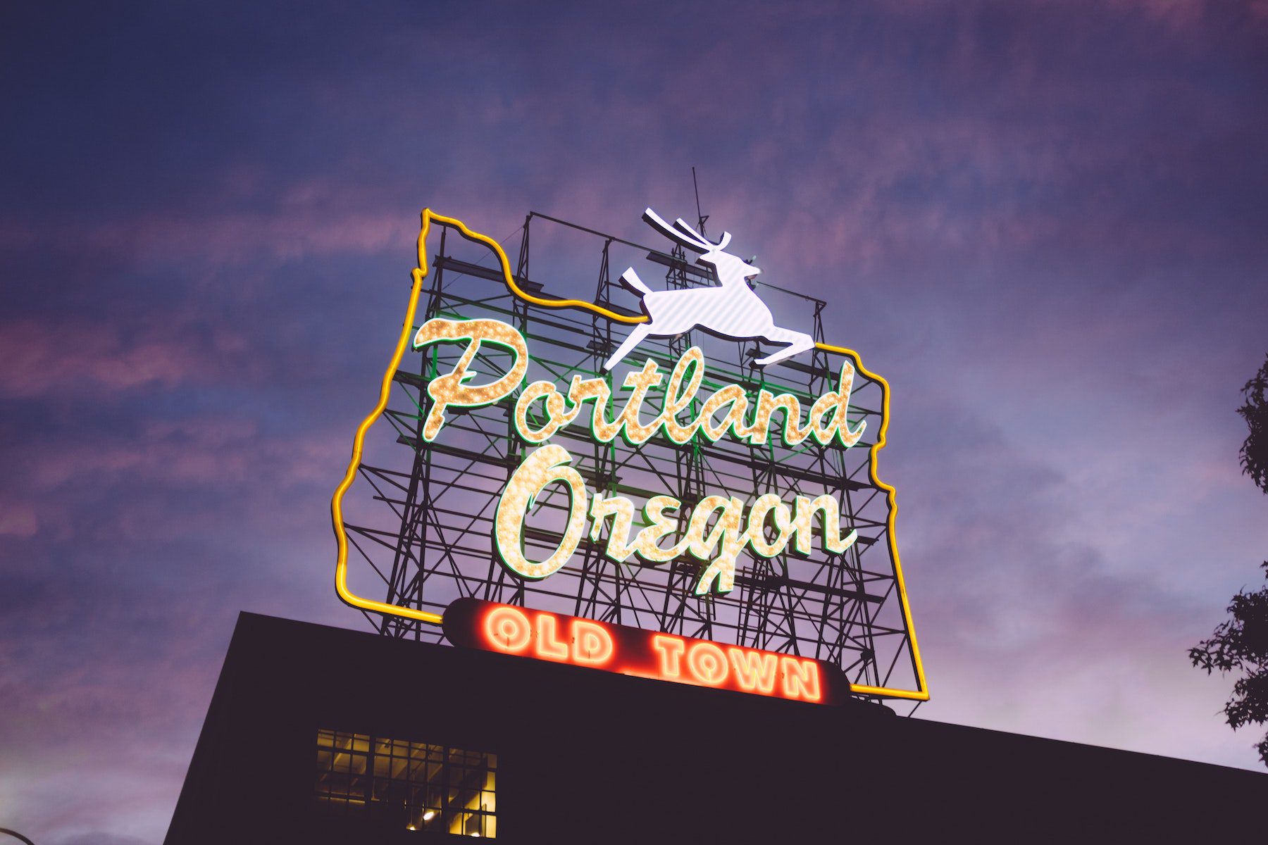 Portland Oregon sign in neon with outline of the state and a deer leaping, reading "Old Town" at bottom.